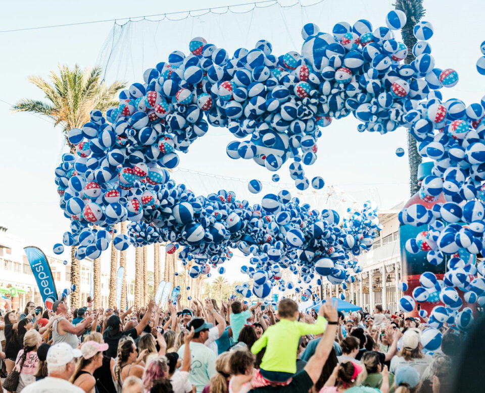 Pepsi beach balls floating over crowd