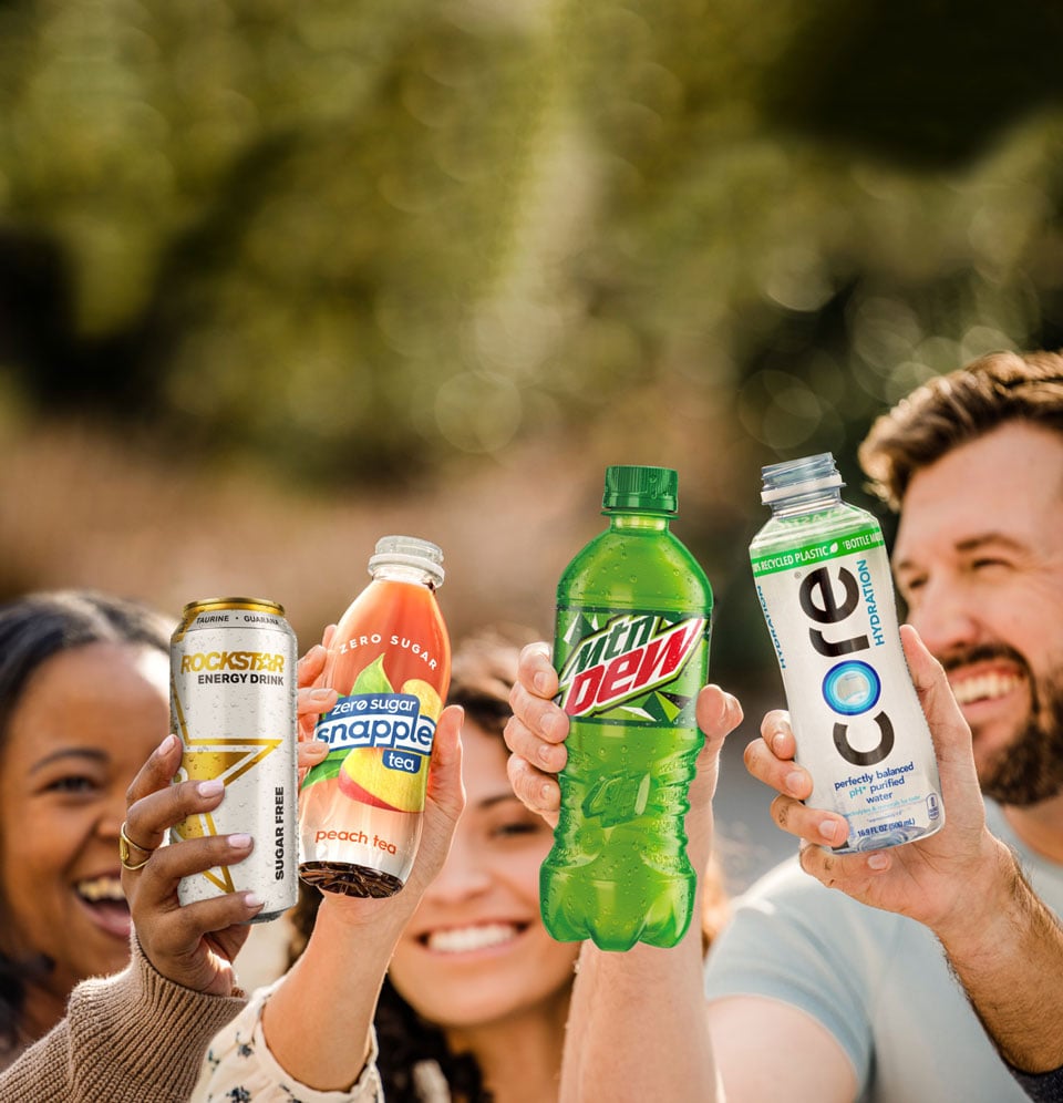 Group of people holding drink cans and bottles